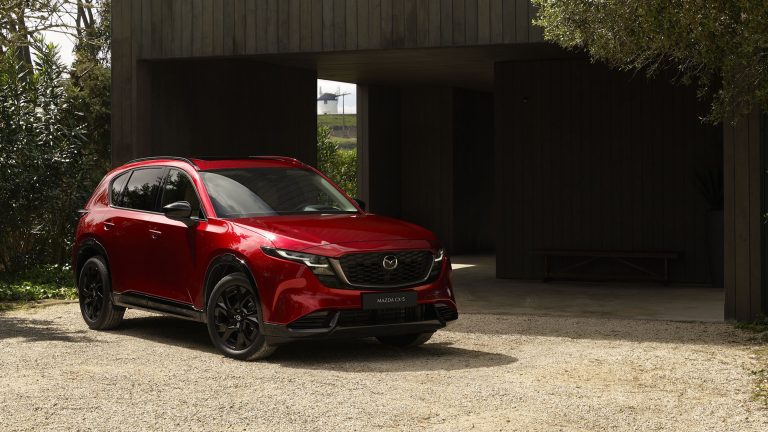 The 2026 Mazda CX-5 parked in a scenic area surrounded by greenery and modern architecture.