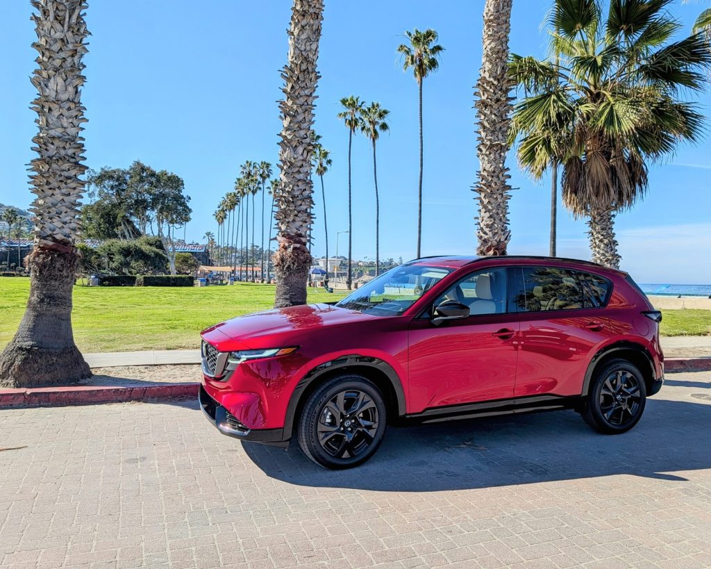 2026 Mazda CX-5 parked along the palm-lined beach in La Jolla on a clear, sunny day.