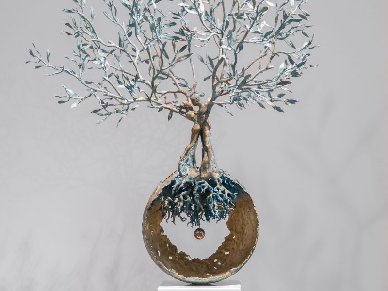 Sculpture titled "Energia della Vita," featuring a tree with a circular base and intricate branches, symbolizing life and harmony.