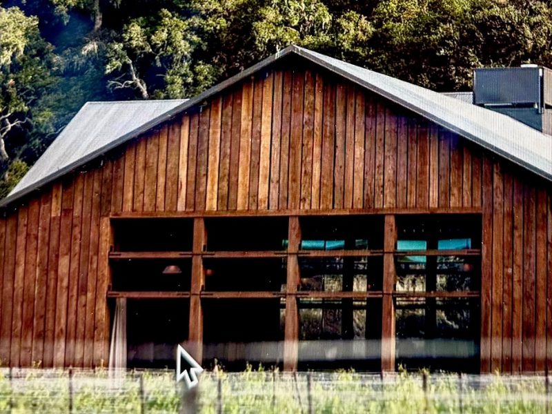 Wooden winery building at The Hilt Estate surrounded by lush greenery in Sta. Rita Hills, California.