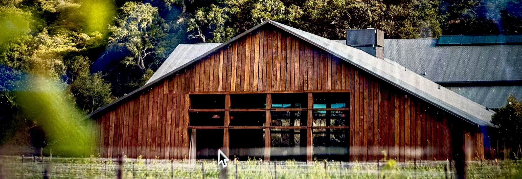 Wooden winery building at The Hilt Estate surrounded by lush greenery in Sta. Rita Hills, California.