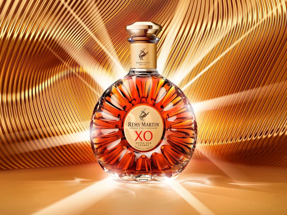 Rémy Martin XO bottle against a shimmering golden background, celebrating International Cognac Day 2026.