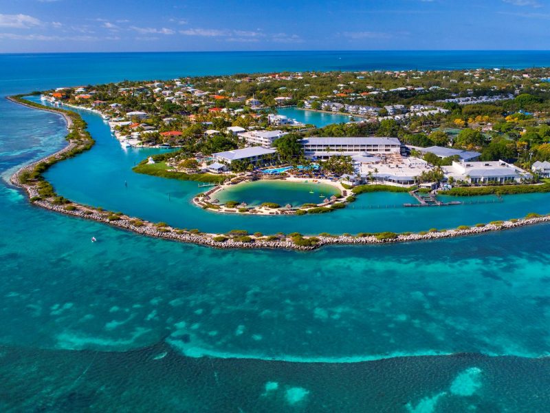 Aerial view of Hawks Cay Resort surrounded by lush greenery and clear turquoise waters in the Florida Keys.