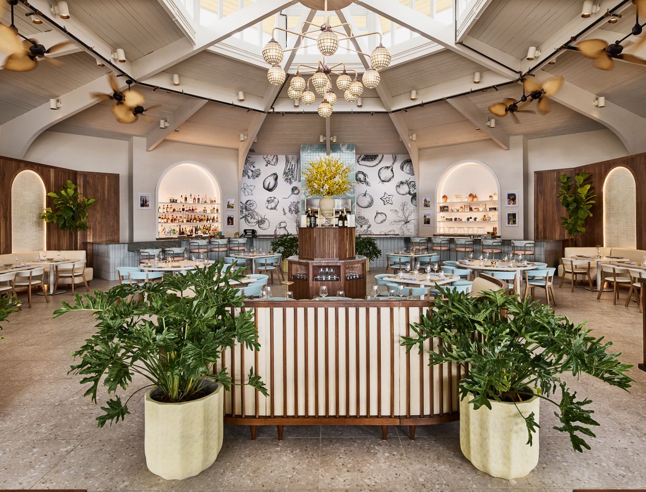 Brightly lit restaurant interior with plants, modern decor, and a bar showcasing a vibrant atmosphere at Hawks Cay Resort.