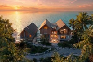 Branded residences by the ocean, featuring modern architecture and sunset views, surrounded by lush tropical landscaping.