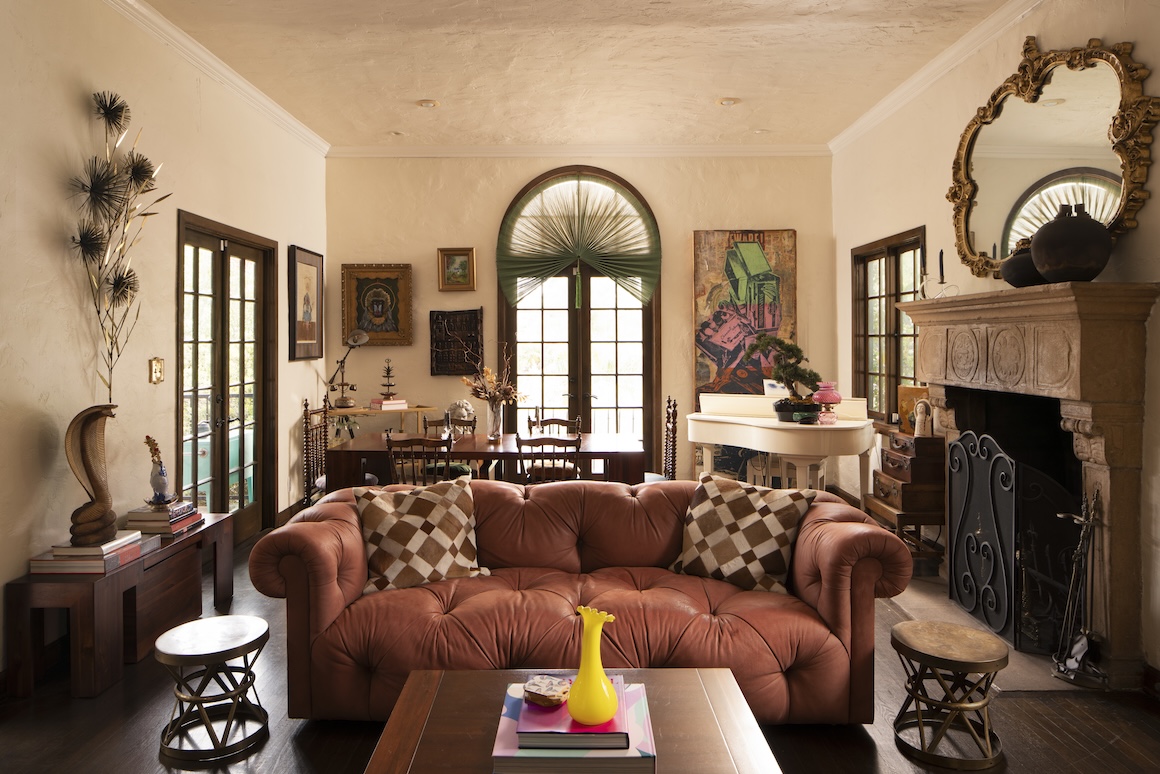 Cozy living room in Casa Ivarene featuring a leather sofa, decorative art, and a fireplace, showcasing elegant interior design.