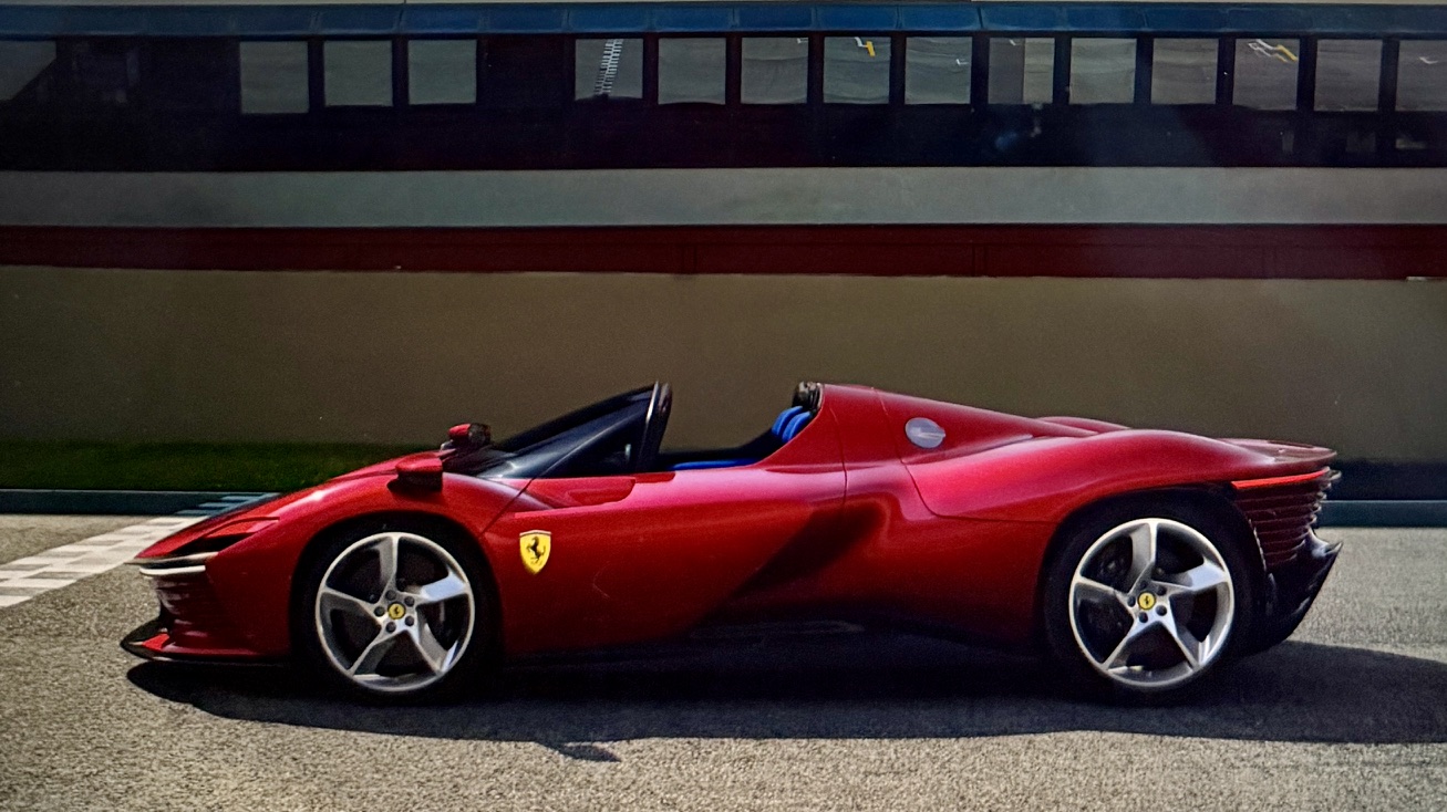 Red luxury Ferrari sports car with a sleek design parked on a racetrack.