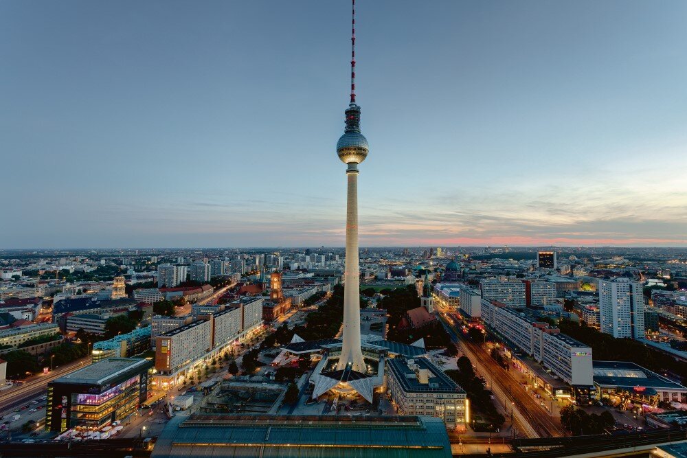 Berlin's iconic TV tower stands tall against a dusky skyline, showcasing the city's vibrant urban landscape.