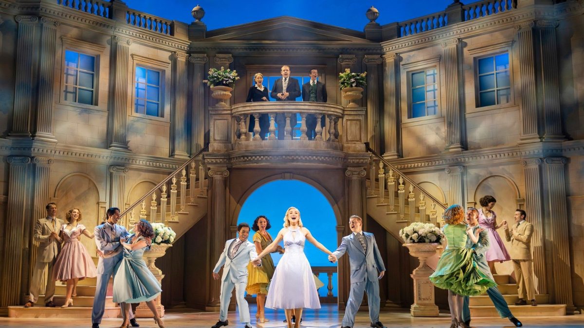 A romantic dance scene from the musical "High Society" set in an elegant venue with actors in period costumes.