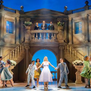 A romantic dance scene from the musical "High Society" set in an elegant venue with actors in period costumes.