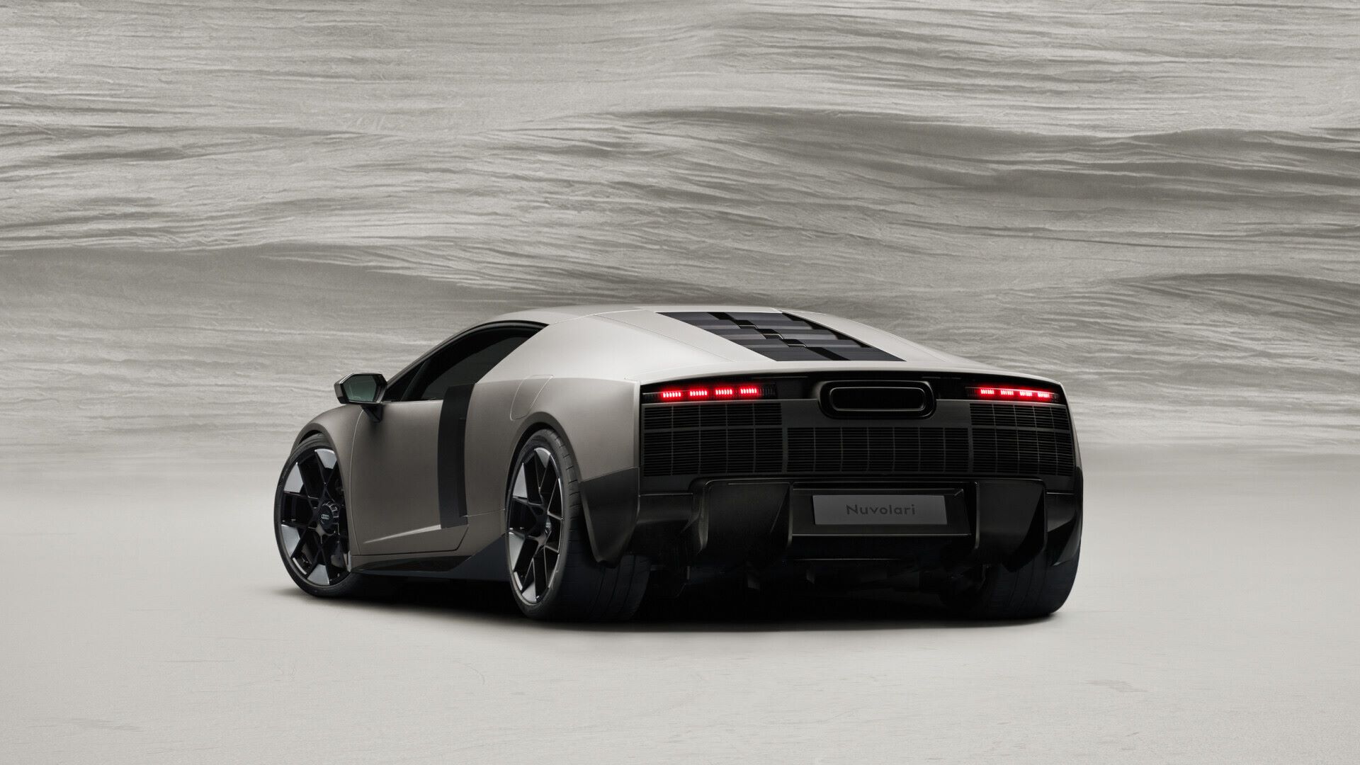Audi's Nuvolari hybrid supercar showcases a striking design with sharp lines and a powerful rear, emphasizing its performance.
