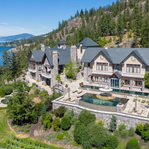 Exclusive waterfront estate overlooking a serene lake, featuring elegant architecture and lush landscaping.