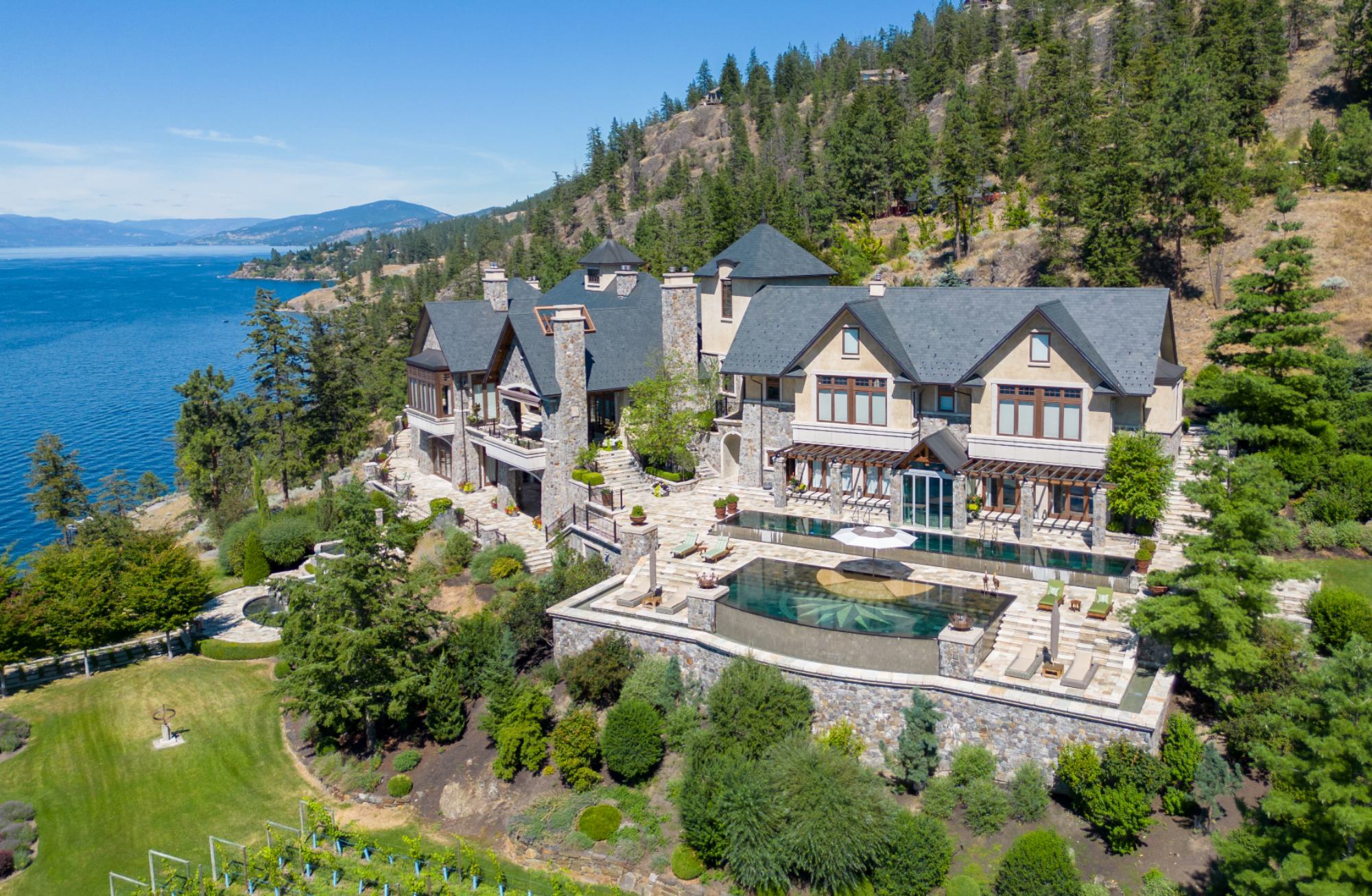 Exclusive waterfront estate overlooking a serene lake, featuring elegant architecture and lush landscaping.