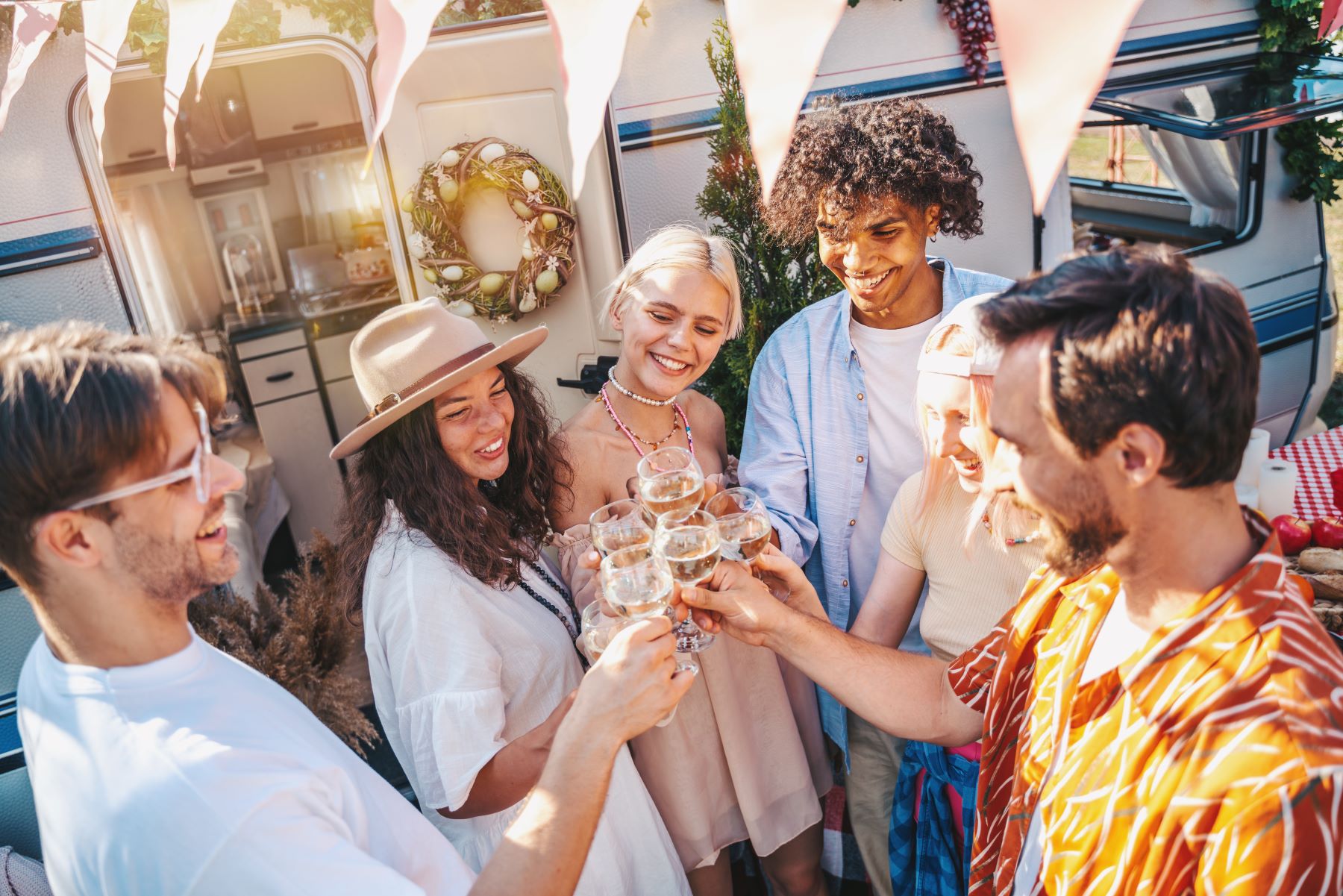 Group of friends celebrating a modern bachelor party with drinks and laughter in a festive outdoor setting.