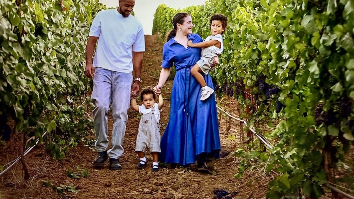 CJ McCollum walks with his family through a vineyard, enjoying a day outdoors surrounded by grapevines.