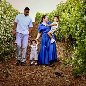 CJ McCollum walks with his family through a vineyard, enjoying a day outdoors surrounded by grapevines.