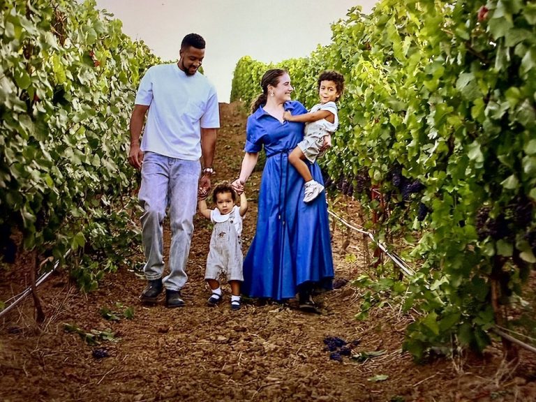 CJ McCollum walks with his family through a vineyard, enjoying a day outdoors surrounded by grapevines.