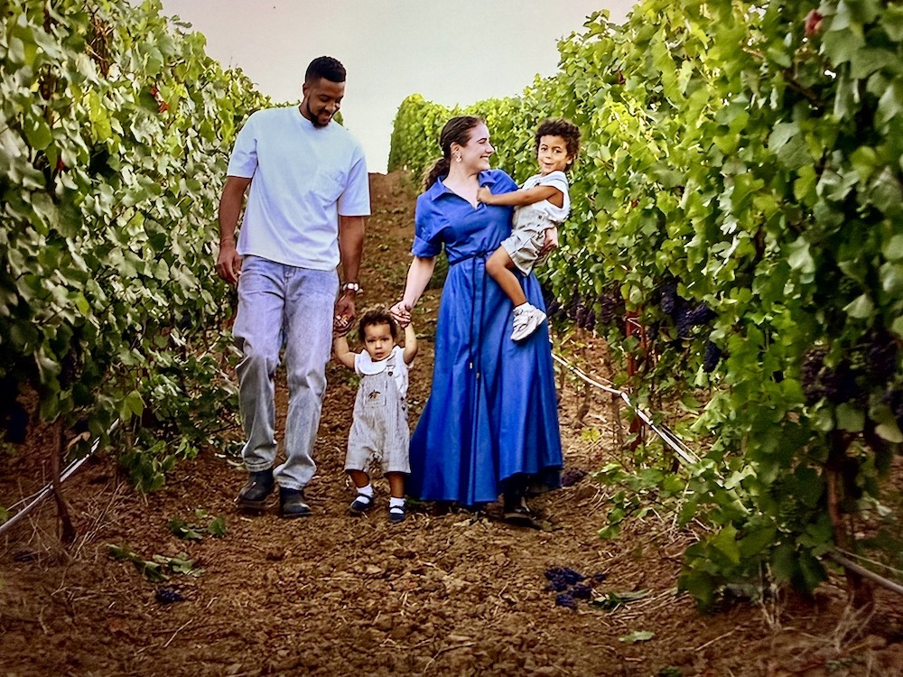 CJ McCollum walks with his family through a vineyard, enjoying a day outdoors surrounded by grapevines.