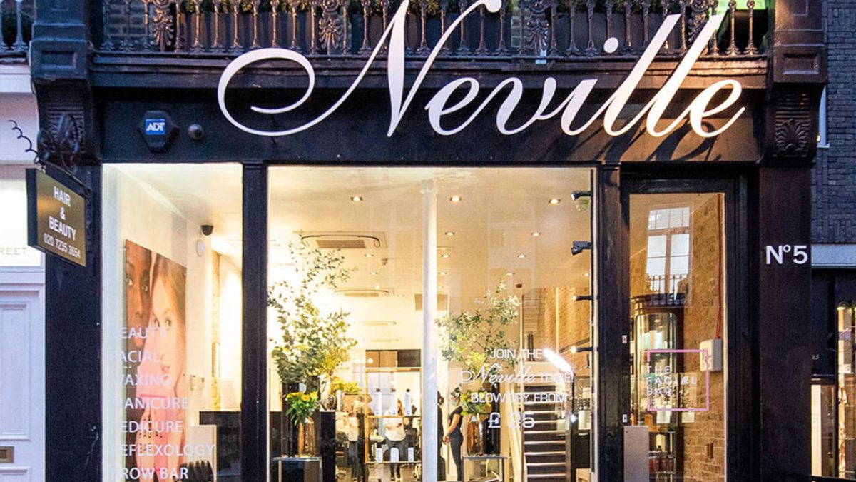 Neville Hair & Beauty storefront featuring elegant signage and lush greenery, inviting customers for hair and beauty services.