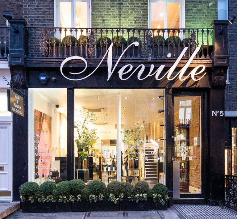 Neville Hair & Beauty storefront featuring elegant signage and lush greenery, inviting customers for hair and beauty services.