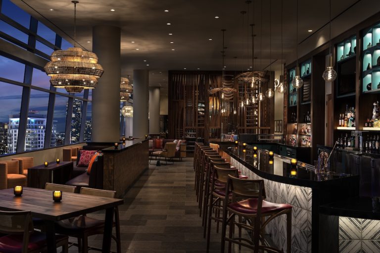 Elegant bar interior at Corteza, featuring ambient lighting, contemporary decor, and city views at The Ritz-Carlton Los Angeles.