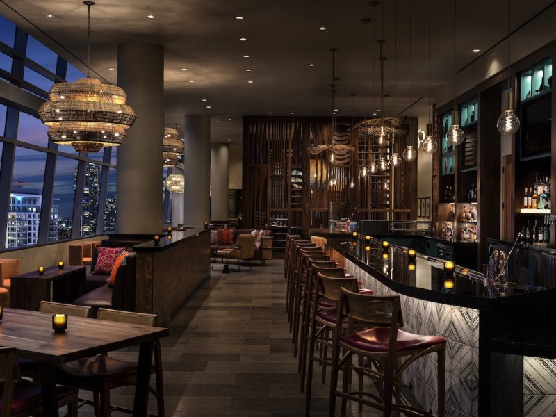 Elegant bar interior at Corteza, featuring ambient lighting, contemporary decor, and city views at The Ritz-Carlton Los Angeles.