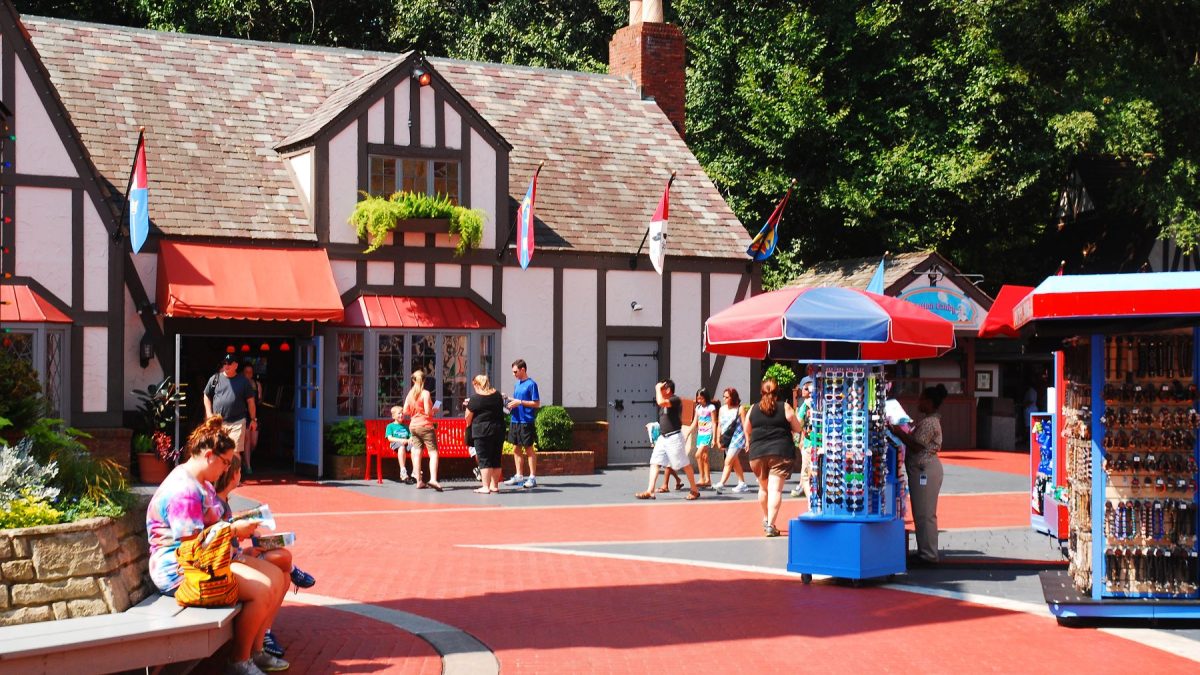 Visitors enjoying a lively marketplace in Williamsburg, VA, with shops, colorful stalls, and people exploring the area.