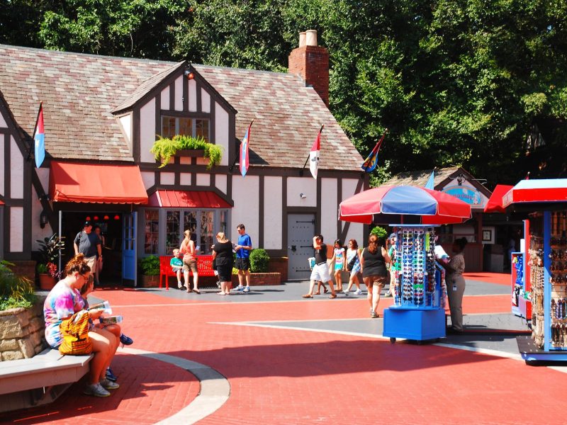 Visitors enjoying a lively marketplace in Williamsburg, VA, with shops, colorful stalls, and people exploring the area.
