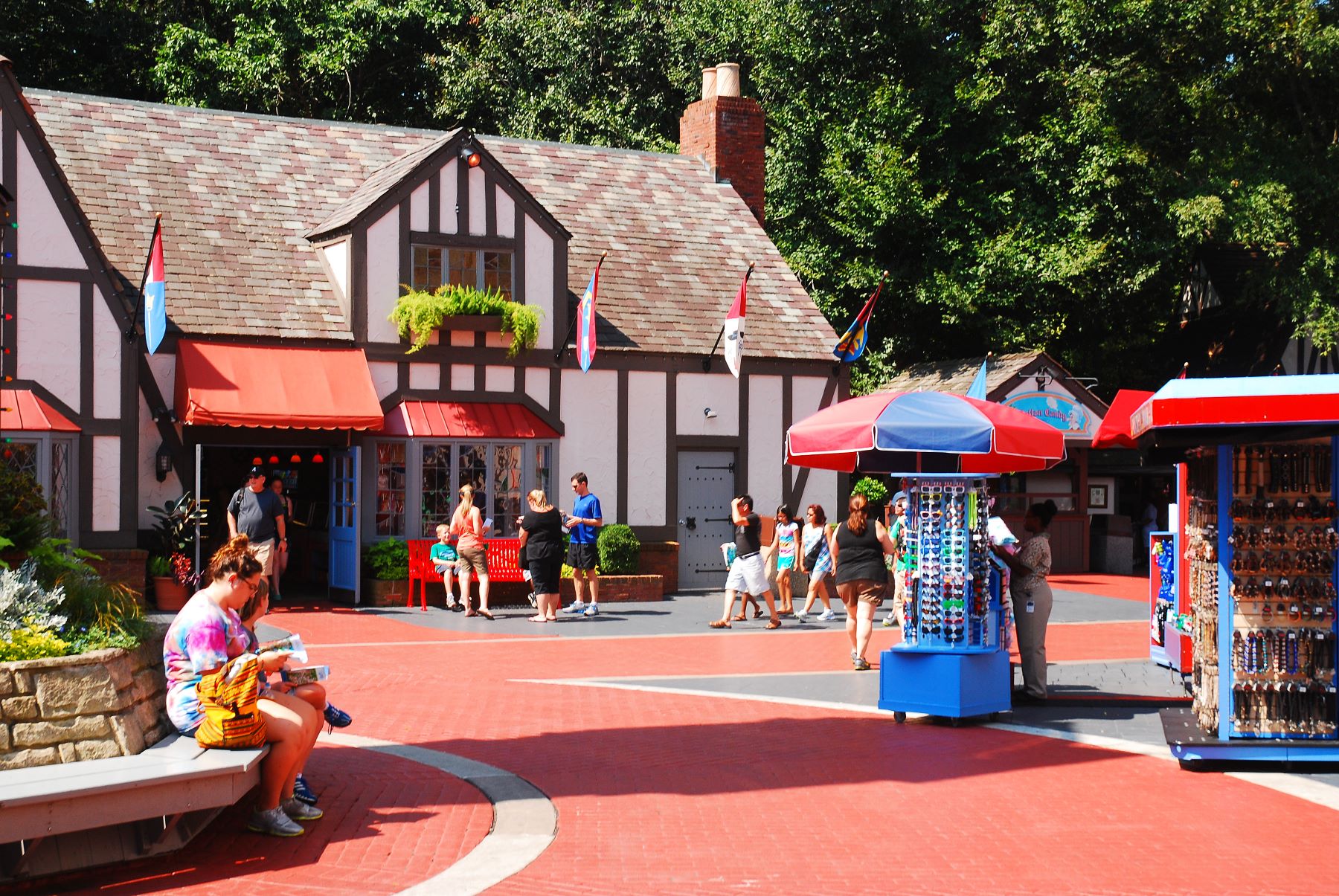 Visitors enjoying a lively marketplace in Williamsburg, VA, with shops, colorful stalls, and people exploring the area.