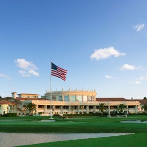 The iconic Trump Doral resort with the American flag, showcasing luxury golf course views and lush landscaping.