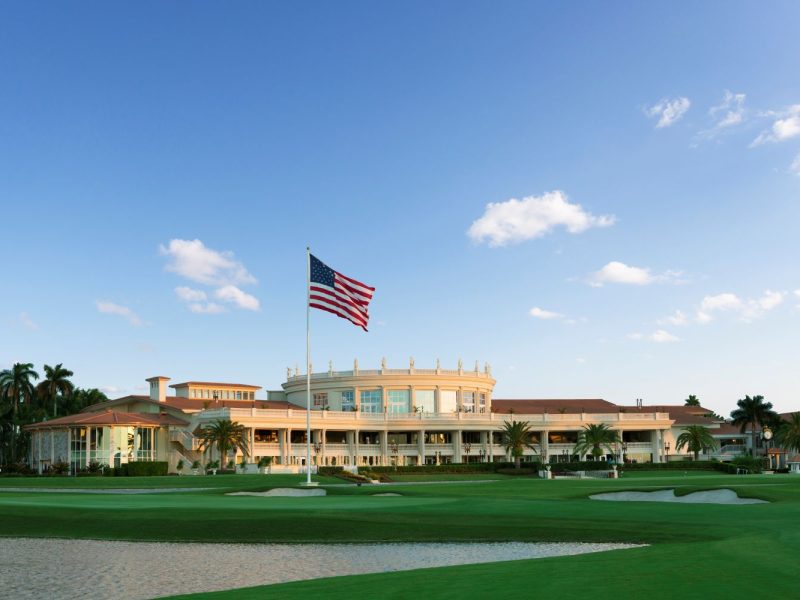 The iconic Trump Doral resort with the American flag, showcasing luxury golf course views and lush landscaping.