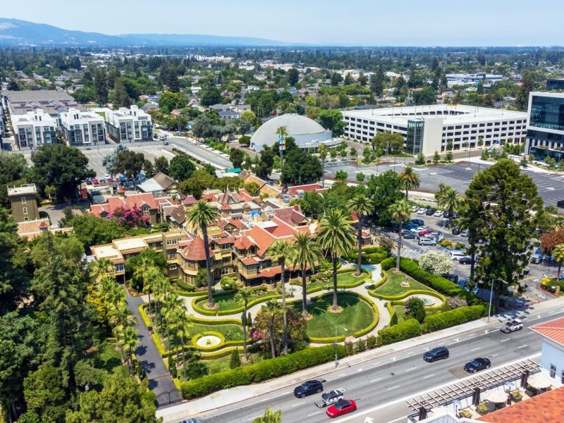 Aerial view of a landscaped area in San Jose featuring palm trees, historic architecture, and surrounding urban development.