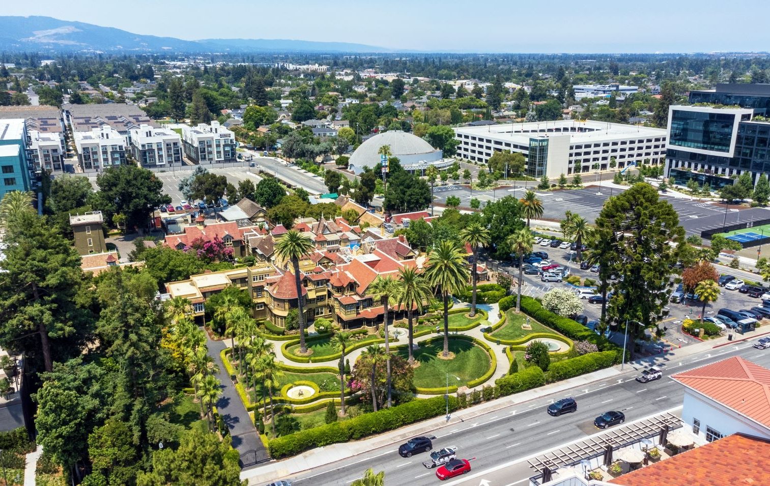 Aerial view of a landscaped area in San Jose featuring palm trees, historic architecture, and surrounding urban development.