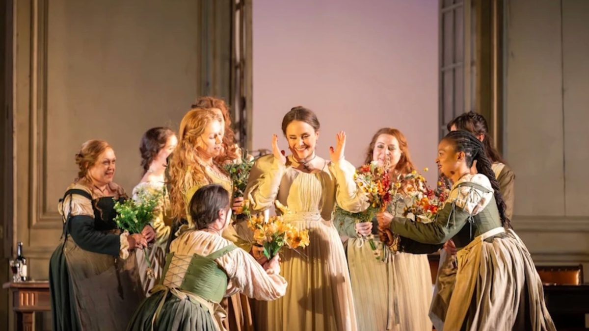 A joyful scene from The Marriage of Figaro at the Royal Opera House, featuring performers celebrating with flowers.