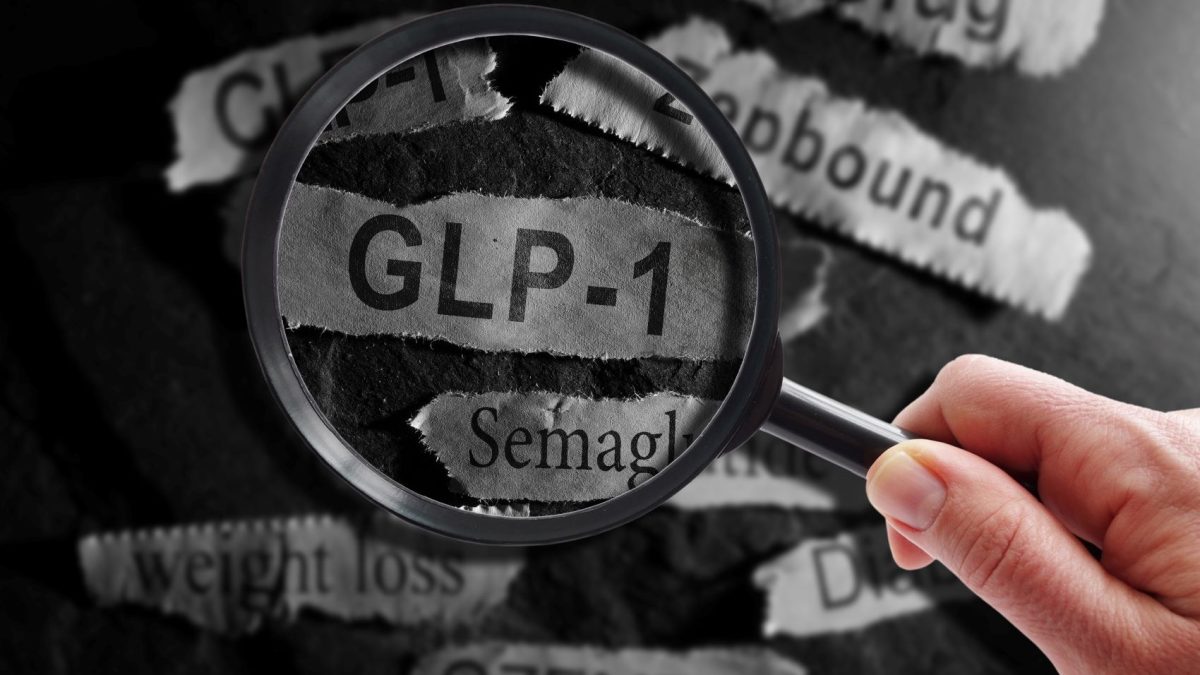 Hand holding a magnifying glass over cut-outs of text featuring GLP-1 and related terms like Semaglutide and weight loss.