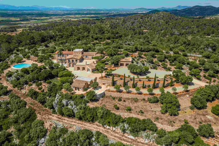 Mallorca hilltop estate featuring panoramic views of the Mediterranean landscape with lush greenery and a swimming pool.