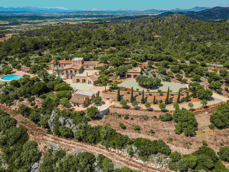 Mallorca hilltop estate featuring panoramic views of the Mediterranean landscape with lush greenery and a swimming pool.