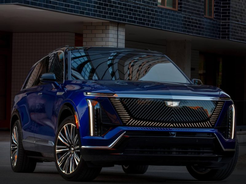 2026 Cadillac VISTIQ Premium Luxury in a stylish blue finish, showcased in an urban setting with modern architecture.