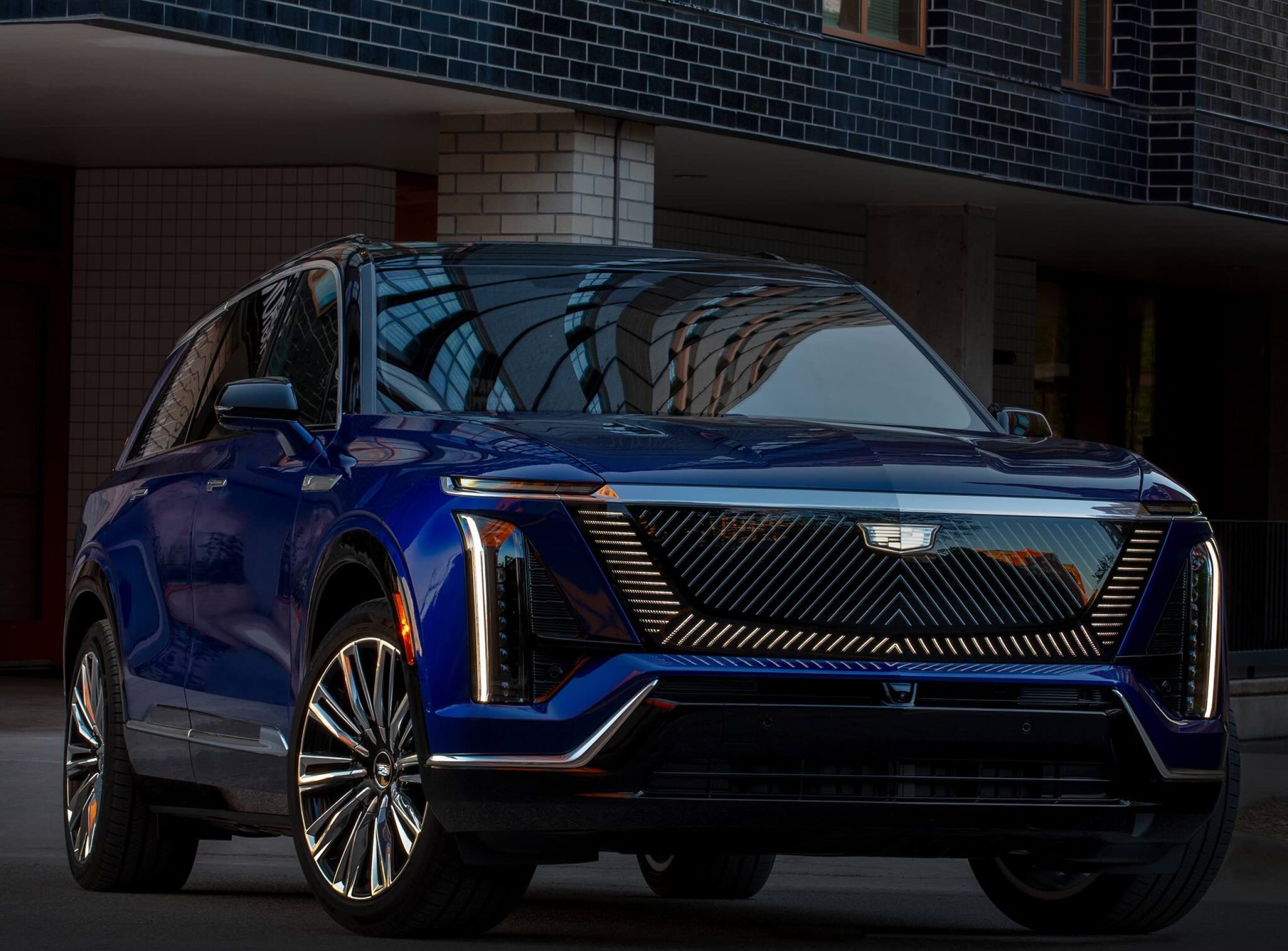2026 Cadillac VISTIQ Premium Luxury in a stylish blue finish, showcased in an urban setting with modern architecture.