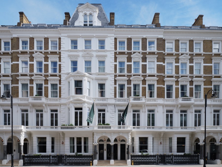 Elegant Victorian-style building with a striking white exterior in South Kensington, featuring arched entrances and flags.