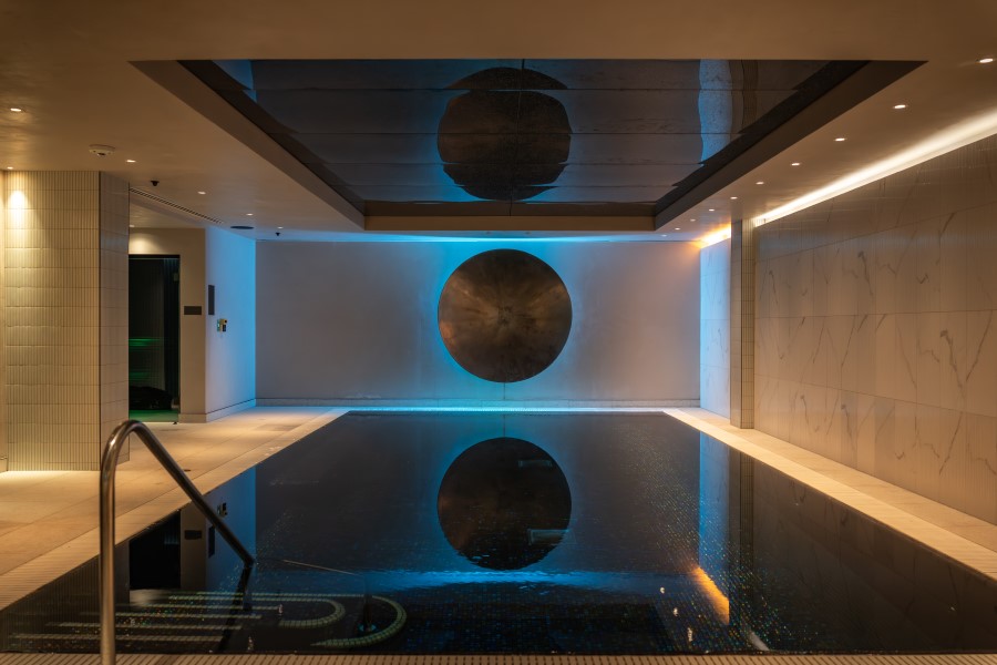 Serene vitality pool with a modern design, illuminated by soft lights and featuring a reflective ceiling.