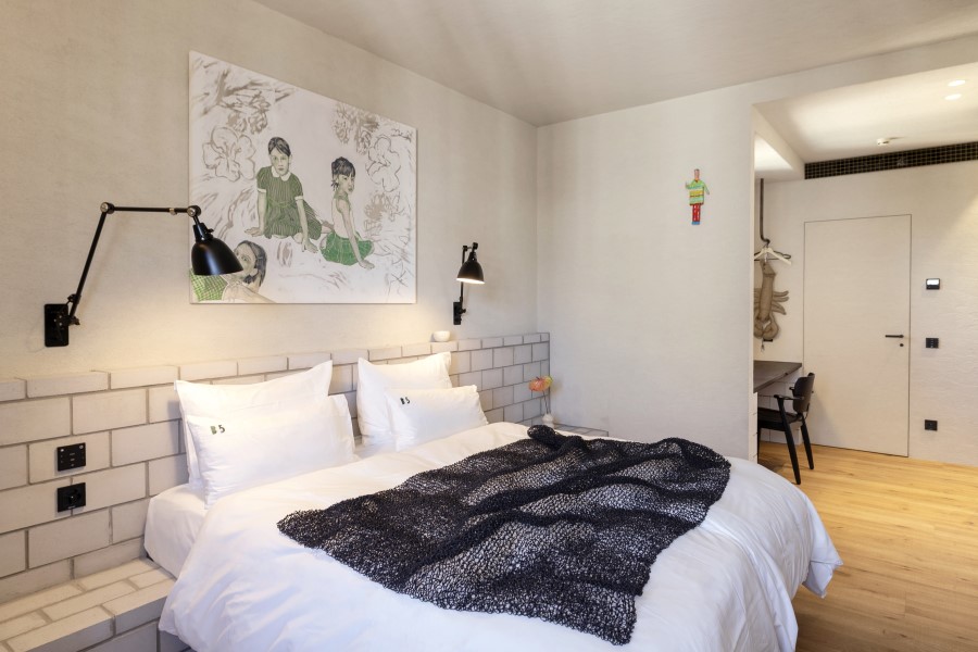 Modern bedroom at B5 Boutique Hotel Lugano featuring a cozy bed, wall art, and stylish lighting.