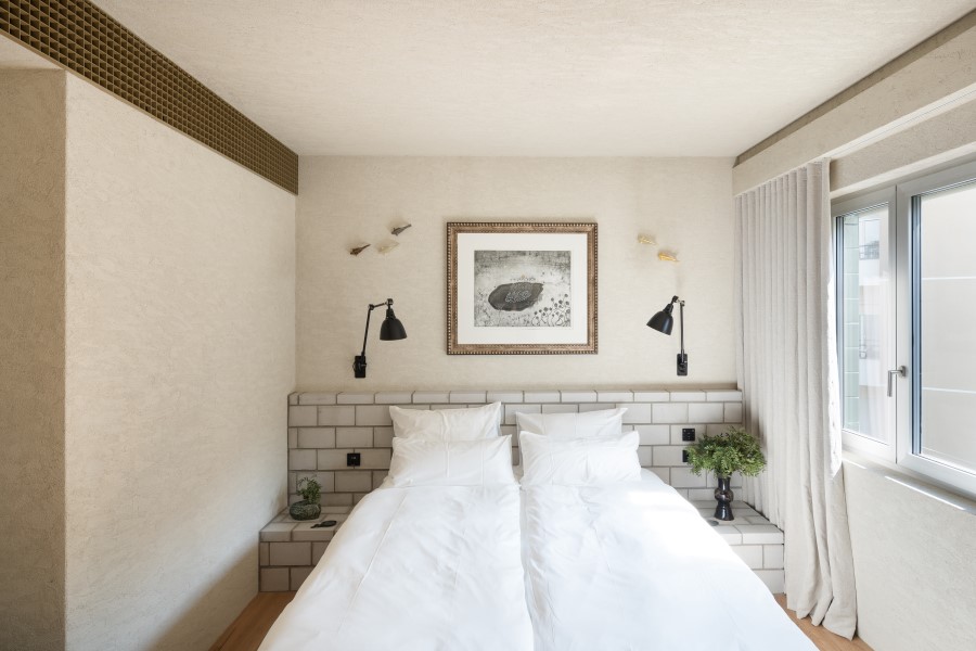 Modern bedroom with twin beds, artwork on the wall, and natural light streaming through the window at B5 Boutique Hotel Lugano.