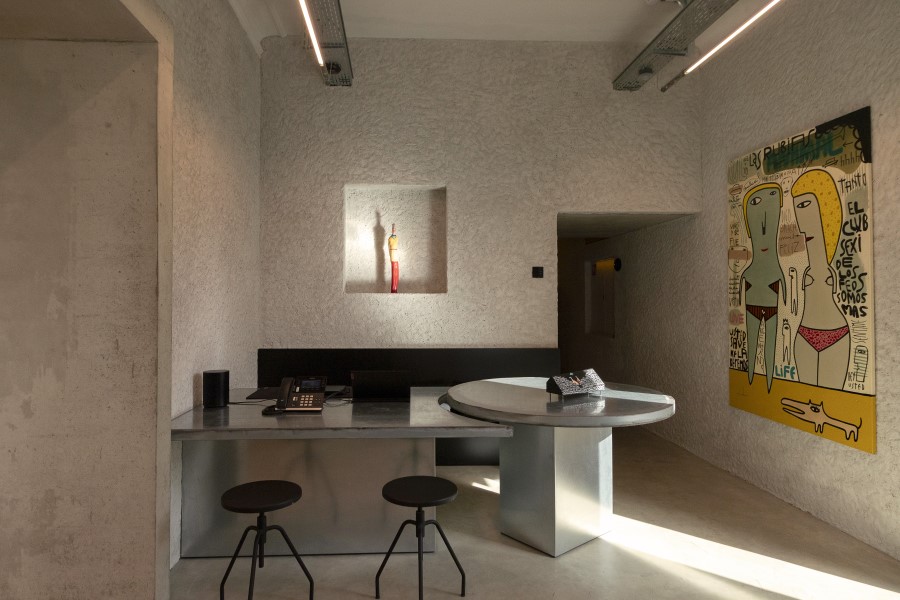 Modern front desk area of B5 Boutique Hotel Lugano, featuring a circular table, minimalist design, and vibrant wall art.