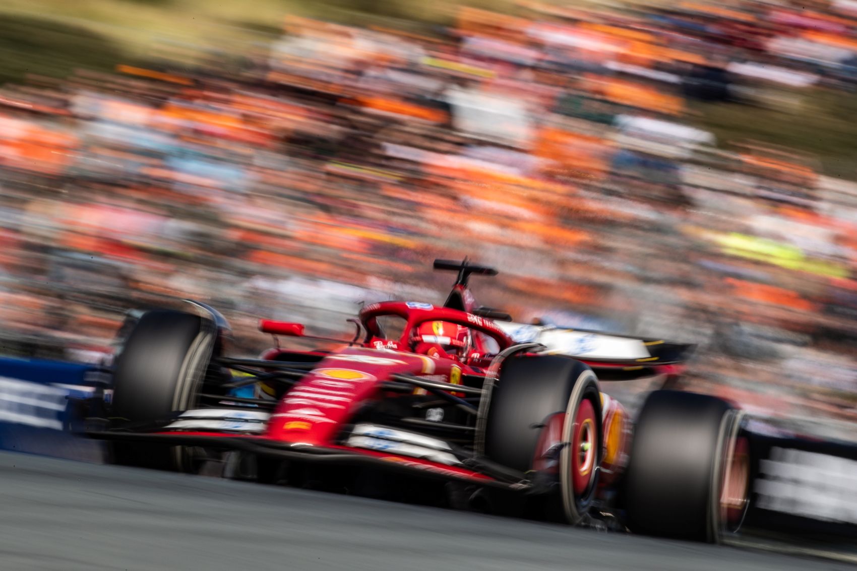 A Ferrari F1 car races past a cheering crowd, capturing the excitement of Europe’s longest luxury sports season.