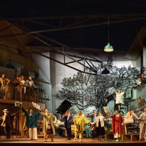 A vibrant scene from L'Orfeo at Glyndebourne, featuring performers in colorful costumes on stage with a dramatic backdrop.