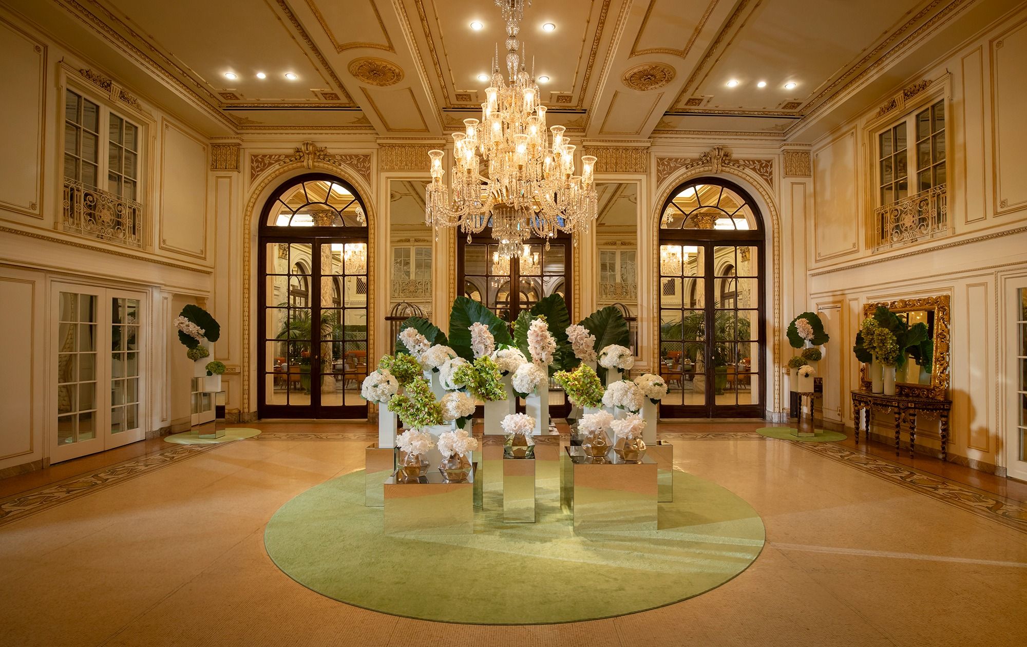 Elegant floral arrangements with a chandelier adorn the luxurious entrance of The Plaza New York.