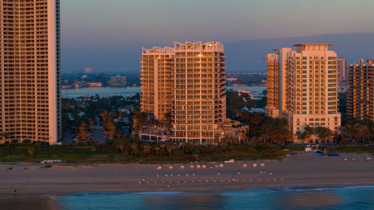 Sunrise over Amrit Ocean Resort on Singer Island, showcasing modern architecture and beachfront access.