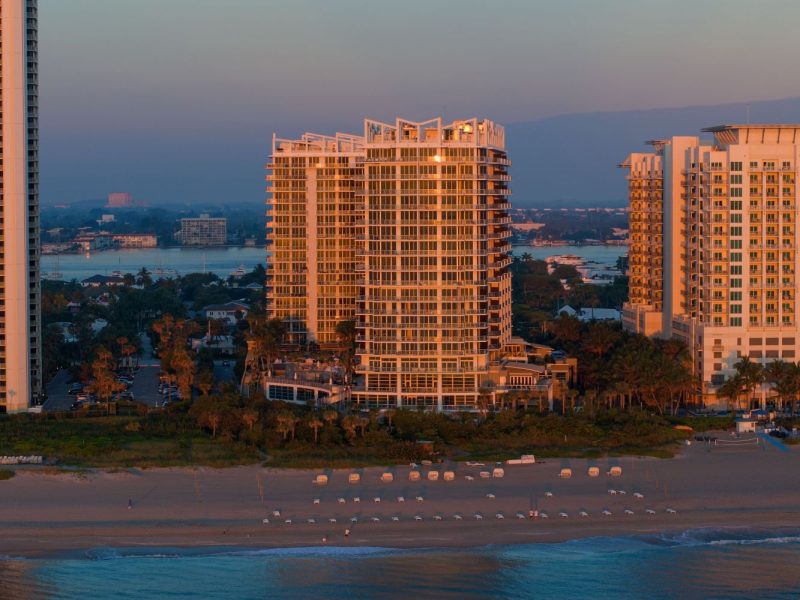 Sunrise over Amrit Ocean Resort on Singer Island, showcasing modern architecture and beachfront access.
