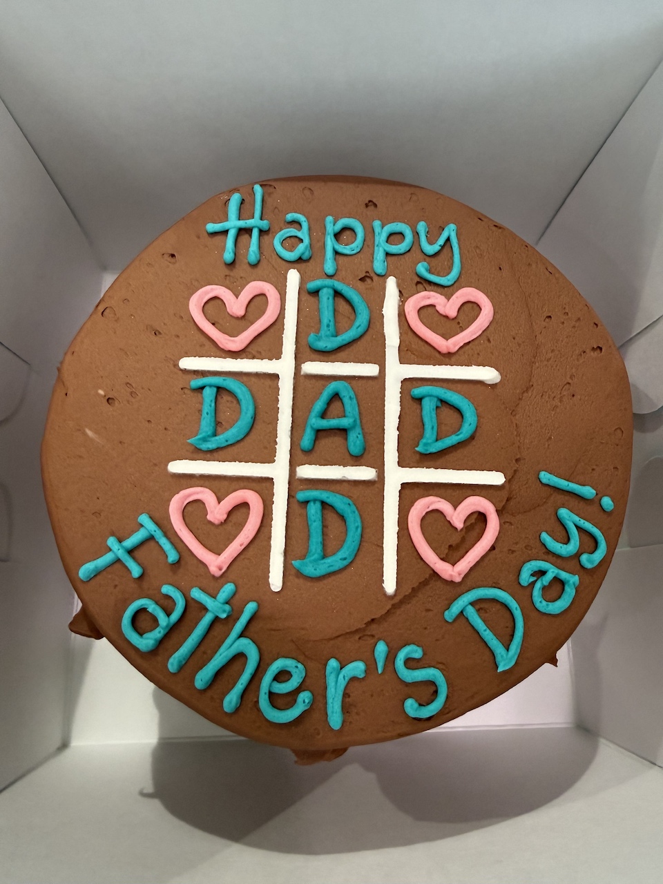 Chocolate cake decorated with colorful icing reading "Happy Father's Day!" and heart designs.